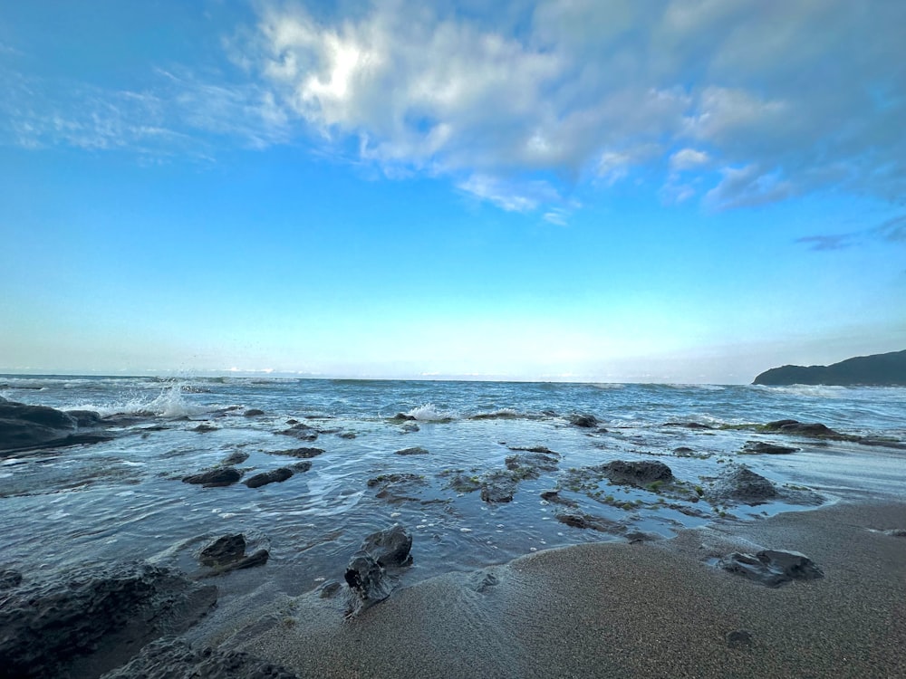 a view of the ocean from a rocky beach