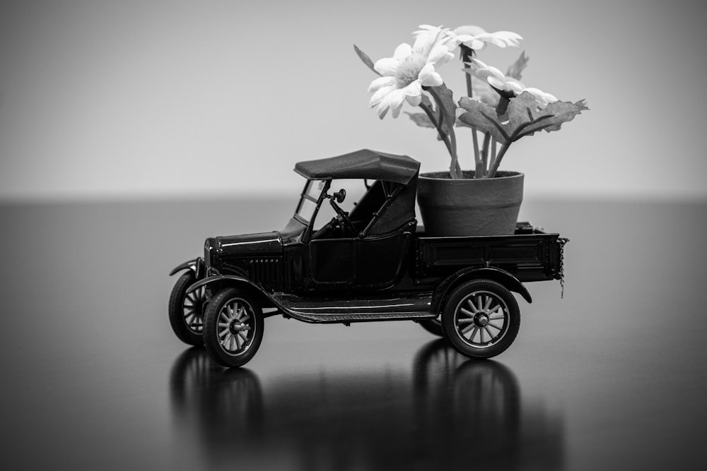 Una foto en blanco y negro de un coche con flores en la parte trasera