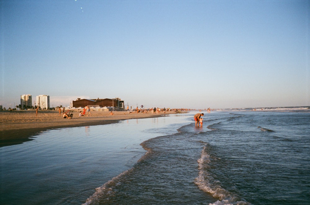 a beach with a few people walking on it