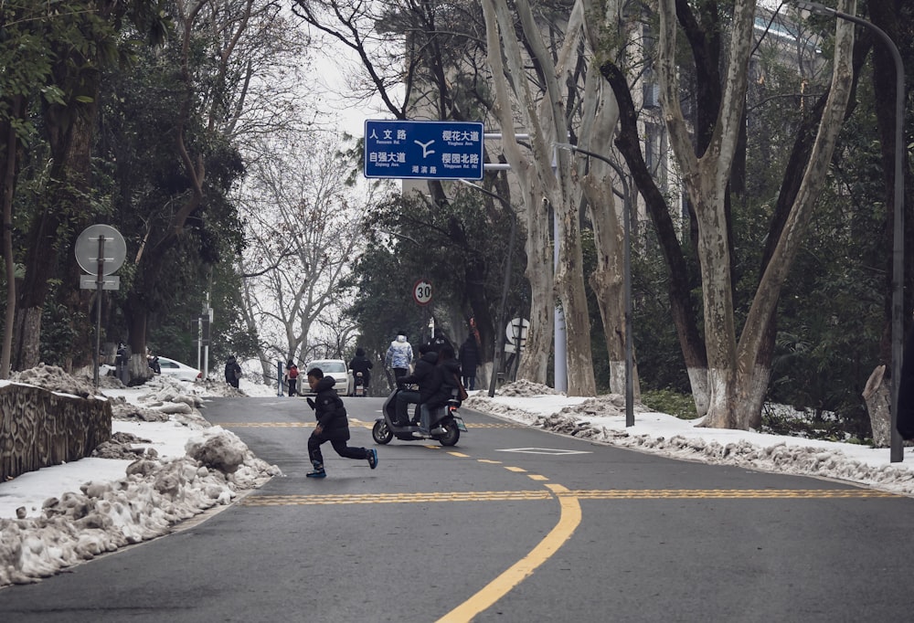 a group of people riding motorcycles down a snow covered street