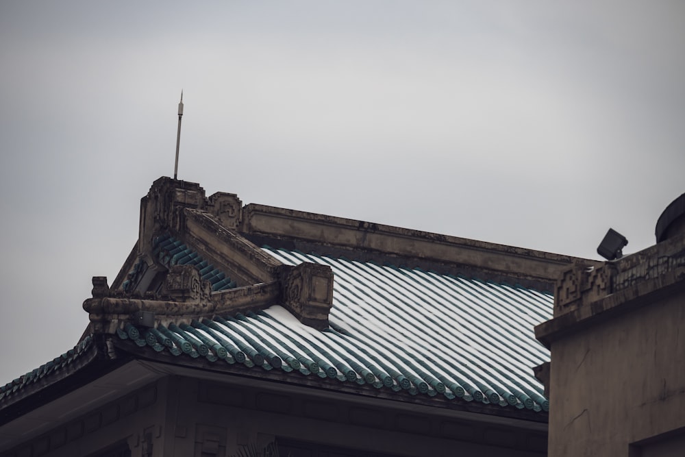 Un pájaro está sentado en el tejado de un edificio