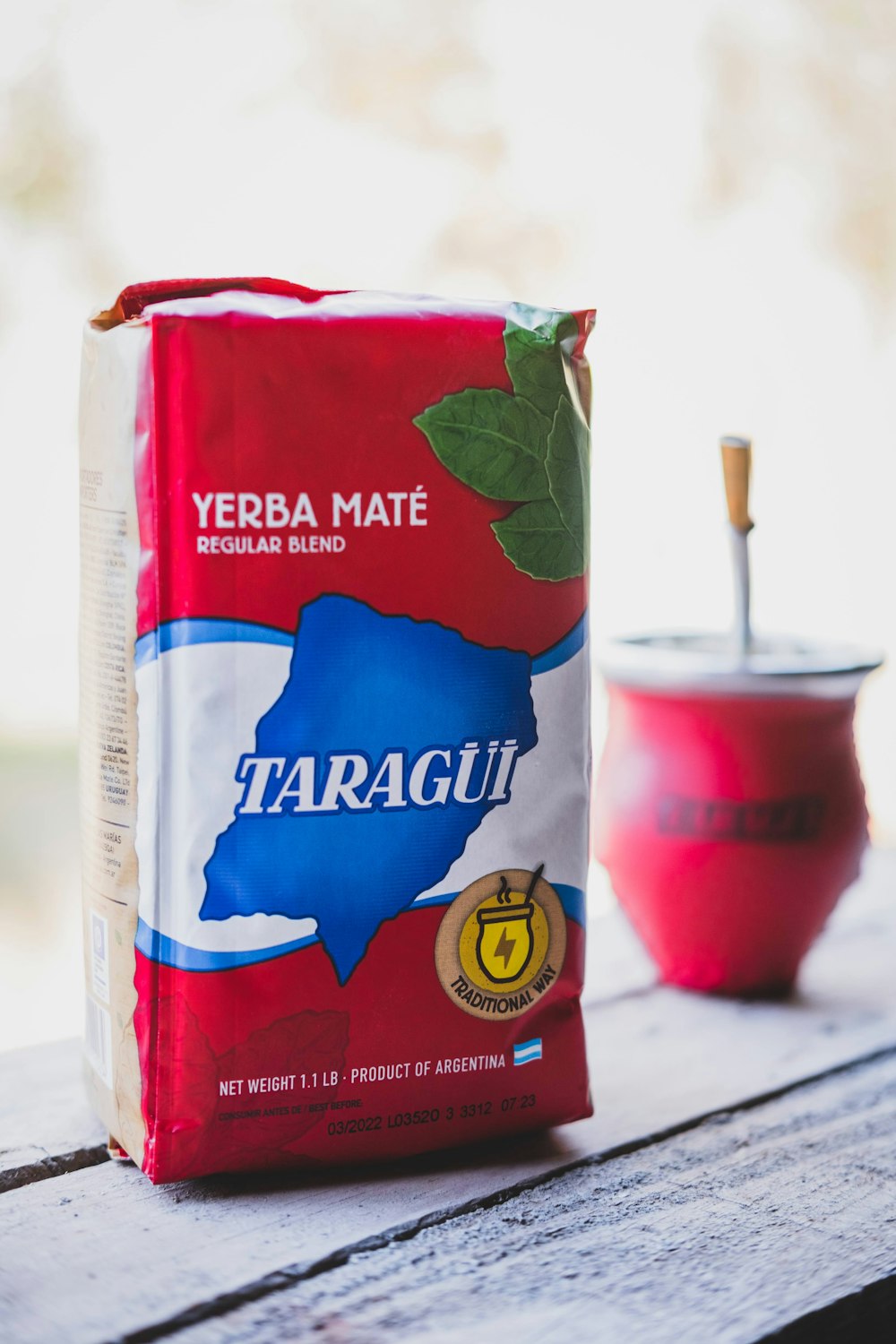 Paquete de yerba mate Taragüi original de 500g apoyado en un banco de madera