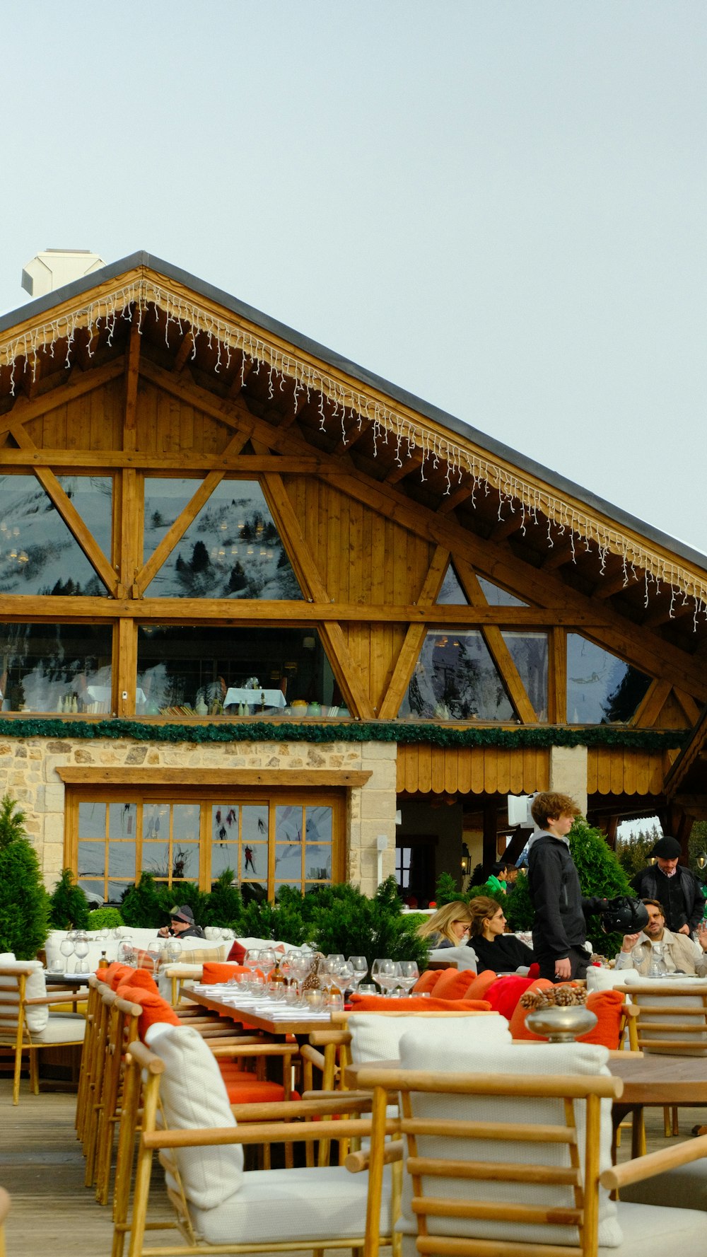 a group of people sitting at tables in front of a building