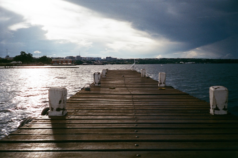 a wooden dock with chairs sitting on it