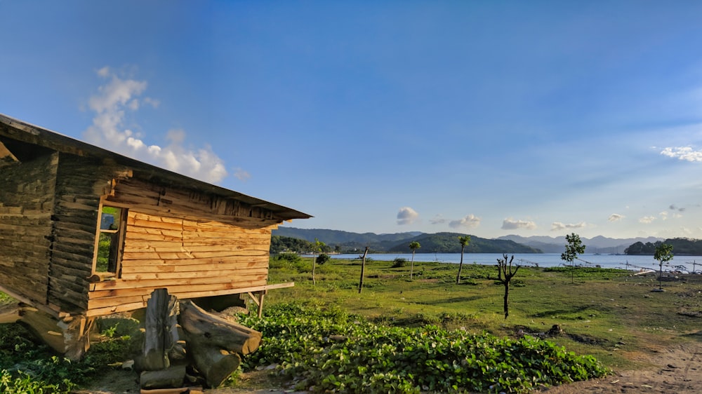 a small wooden cabin sitting on top of a lush green field