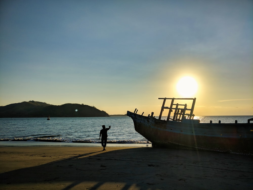 a boat sitting on top of a beach next to the ocean