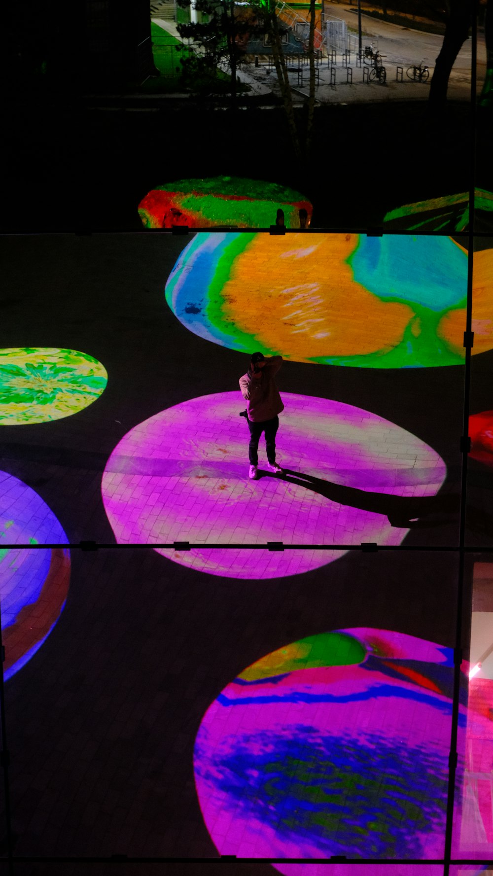 a person standing in front of a display of colorful circles