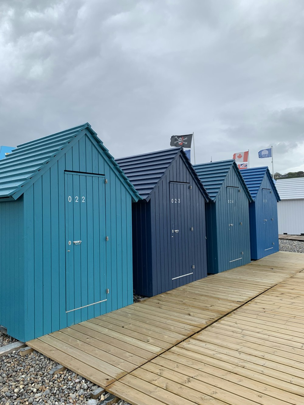 eine Reihe von Strandhütten auf einem hölzernen Steg