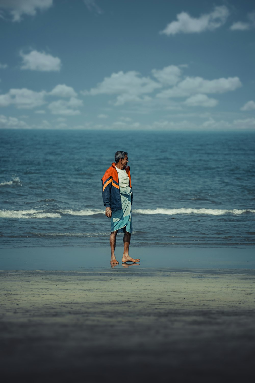 a man standing on a beach next to the ocean