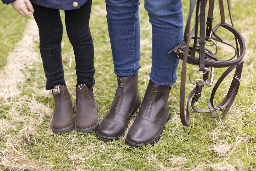 a couple of people standing next to a brown horse