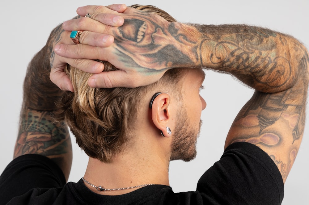 a man with tattoos covering his face and hands