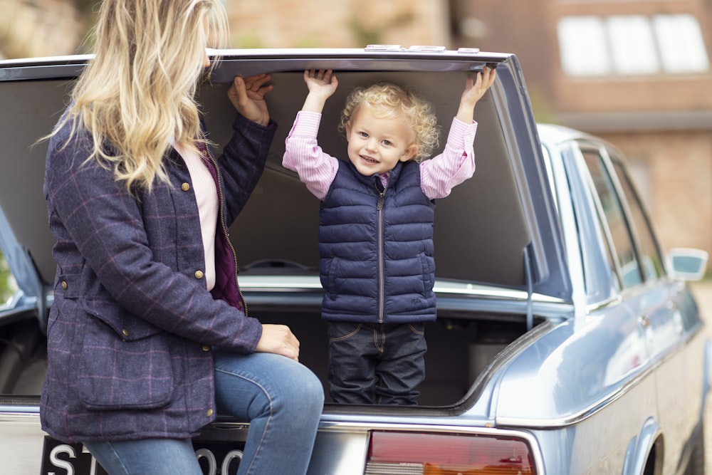 a woman and a child sitting in the back of a car