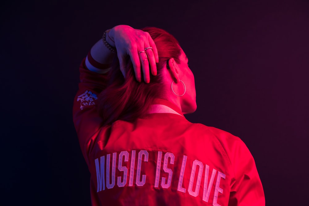 a woman wearing a red shirt with music is love on it