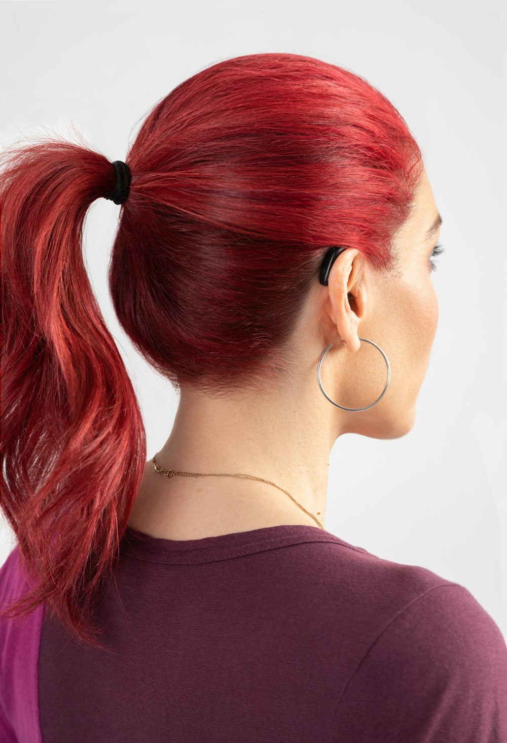 a woman with red hair wearing a ponytail