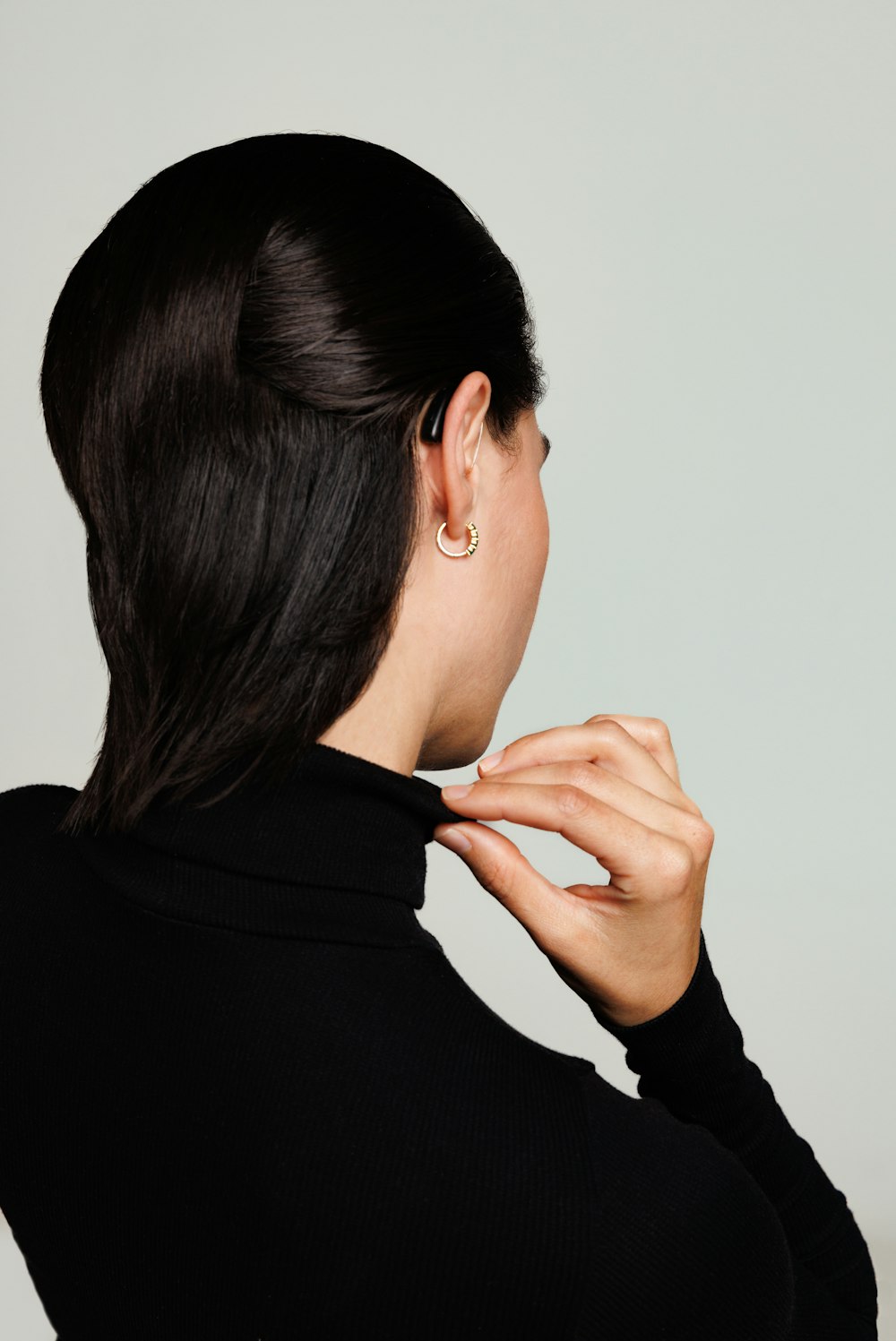 a woman wearing a black shirt and a pair of earrings