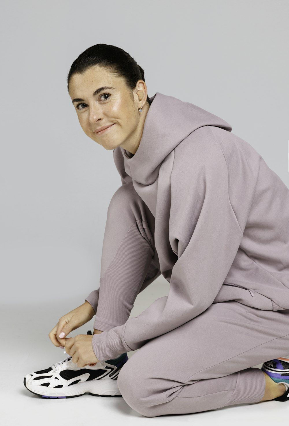 a woman sitting on the ground in a purple outfit
