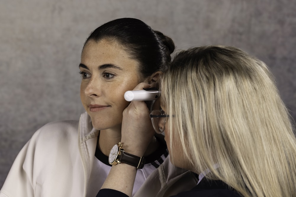 a woman talking on a cell phone next to another woman