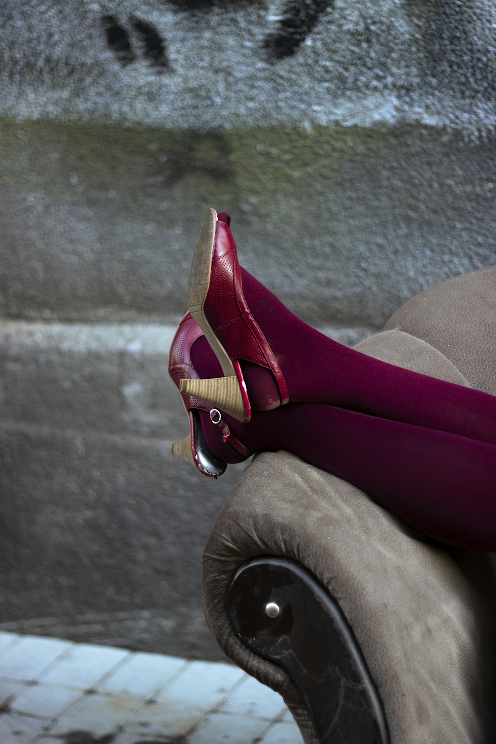 a pair of red high heeled shoes sitting on top of a couch