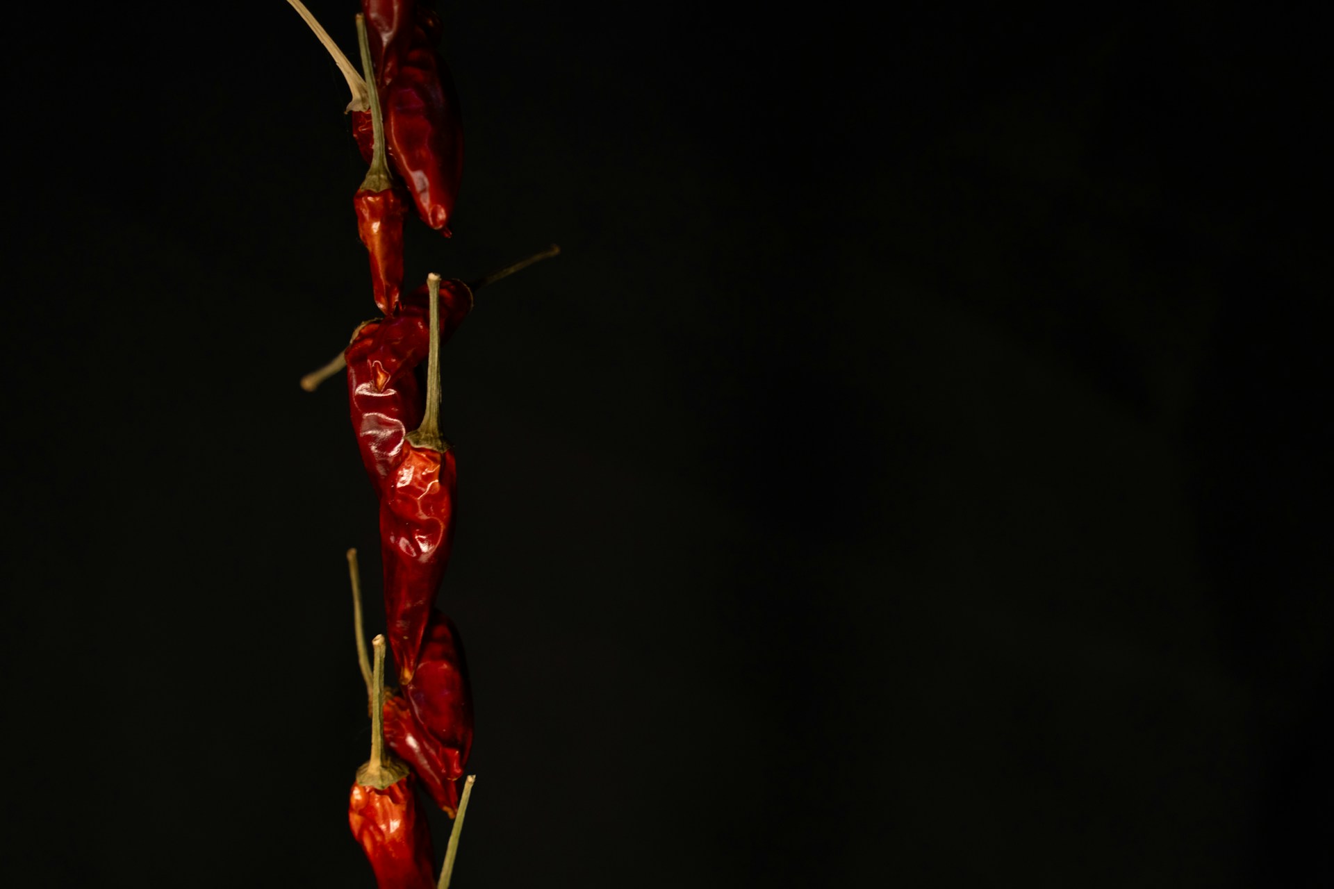 a bunch of red peppers on a black background