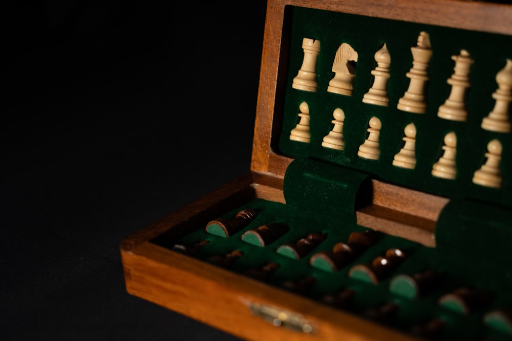 a wooden box filled with chess pieces on top of a table