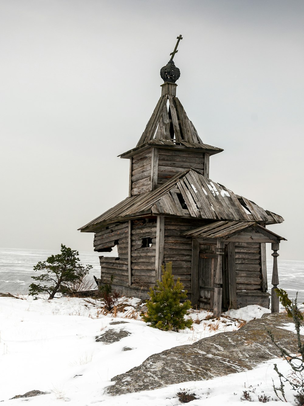 an old wooden church with a steeple in the snow
