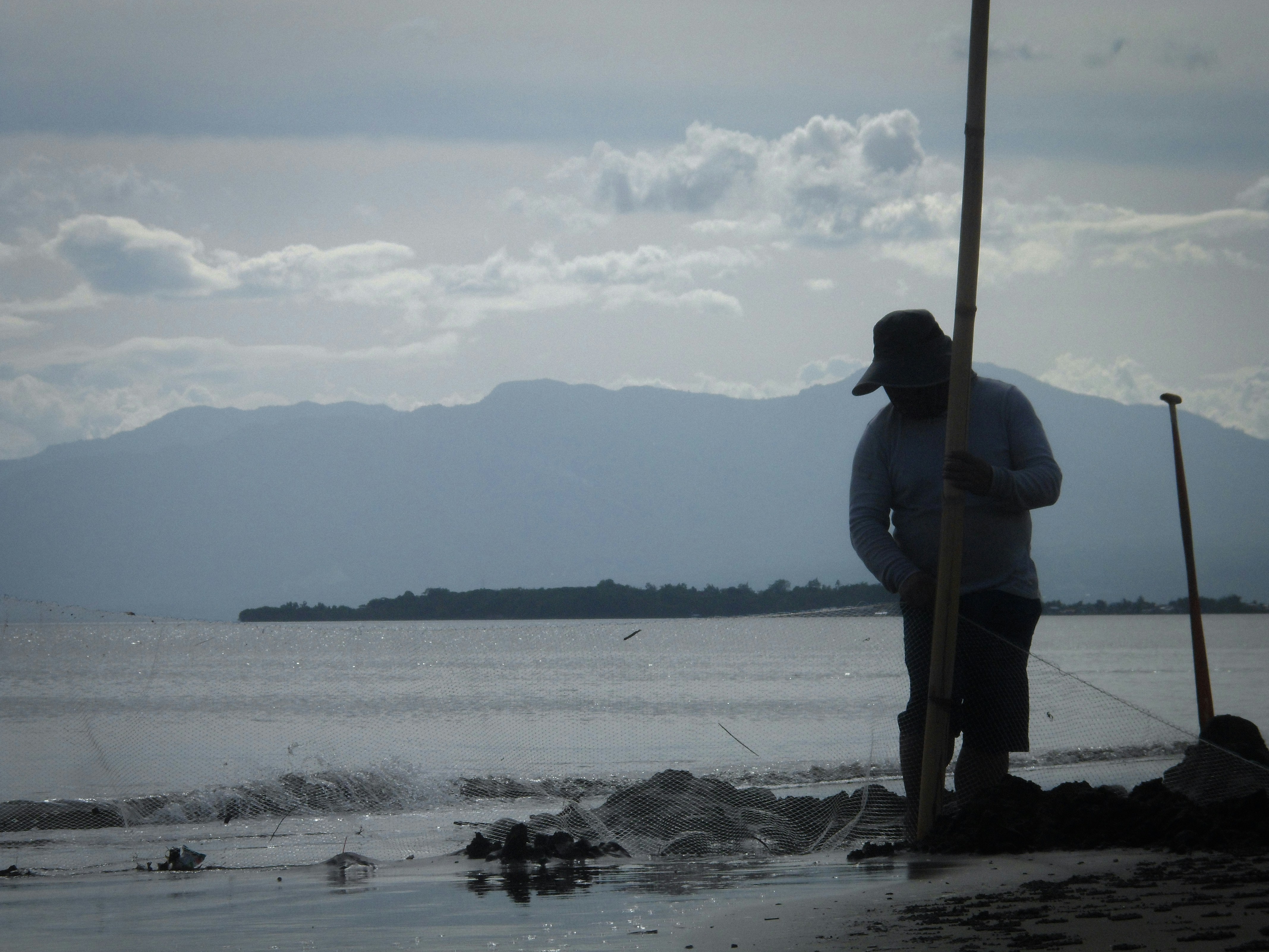 ein Mann, der an einem Strand neben einem Gewässer steht
