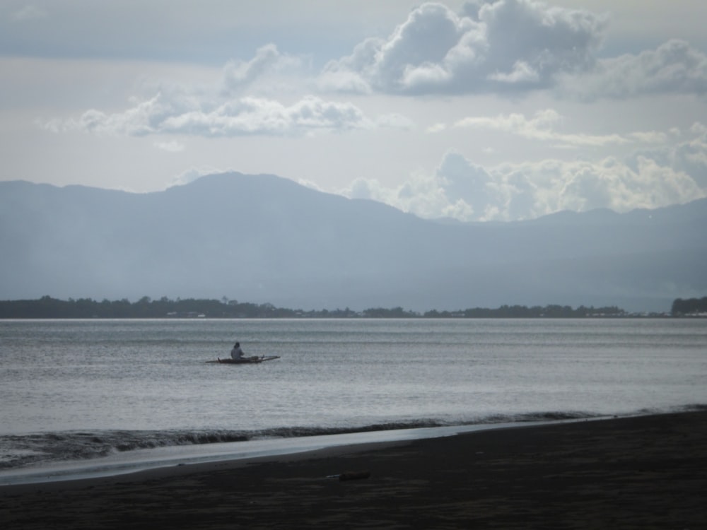 a person in a small boat on a body of water