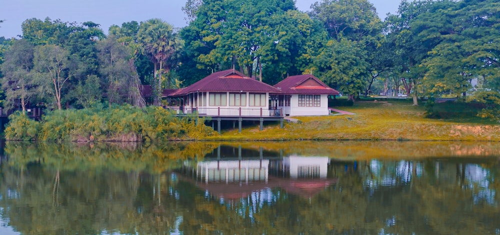 a house sitting on top of a lush green field next to a lake