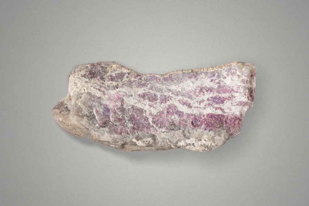 a rock with a pink and white substance on it