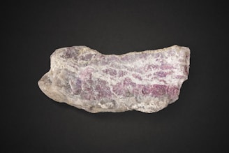 a rock with a pink and white substance on it