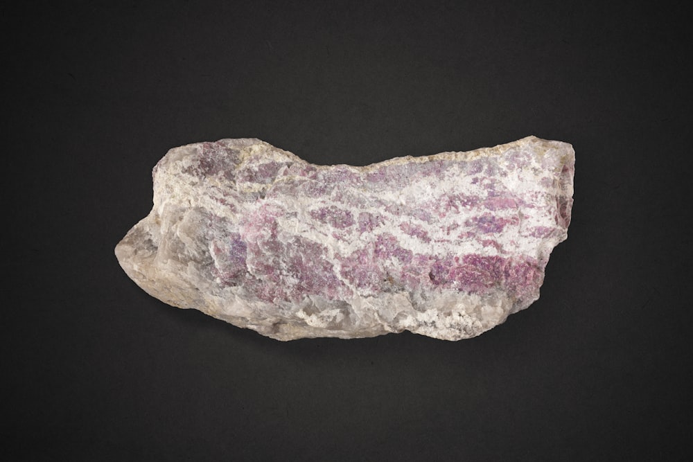 a rock with a pink and white substance on it