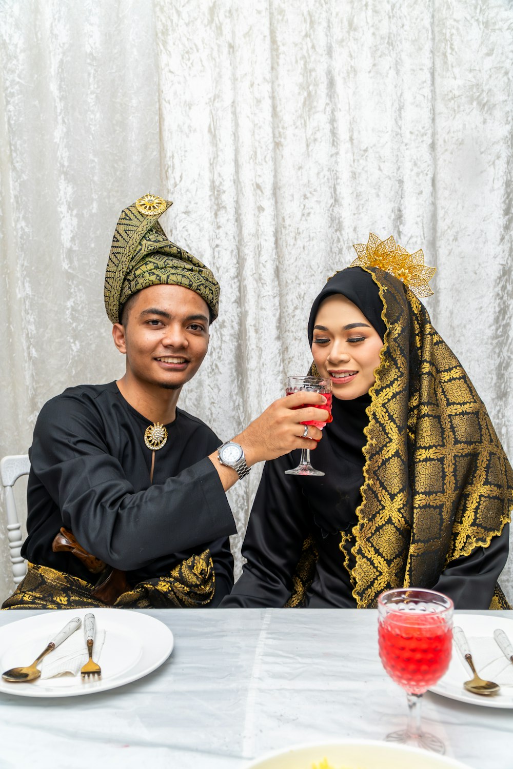 a man and woman sitting at a table with a glass of wine