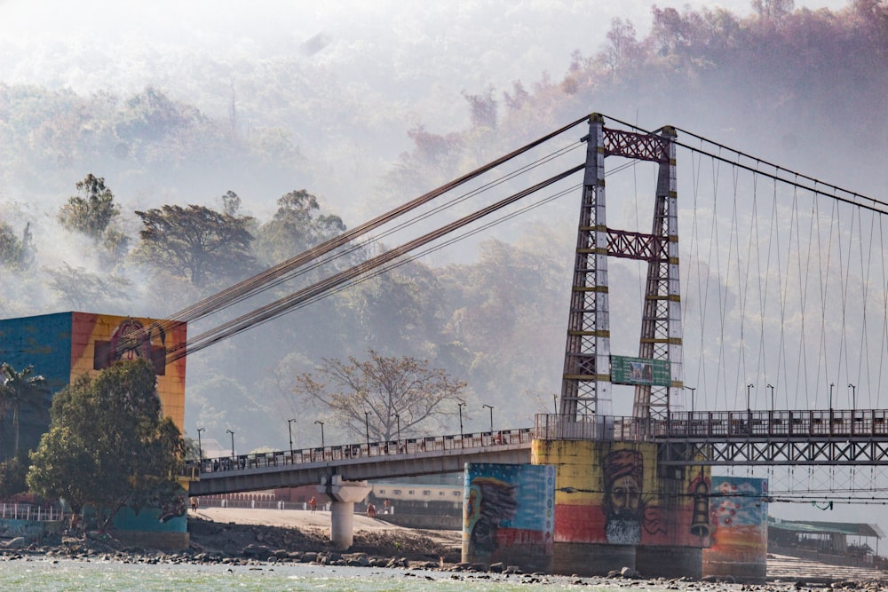 a bridge over a body of water with trees in the background