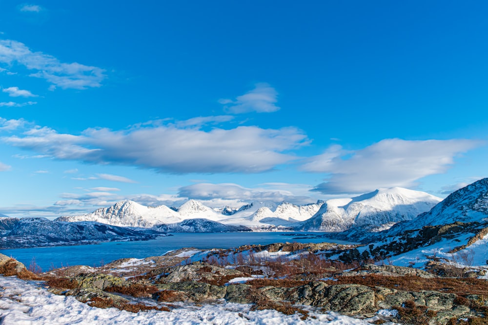 a snow covered mountain with a body of water in the distance