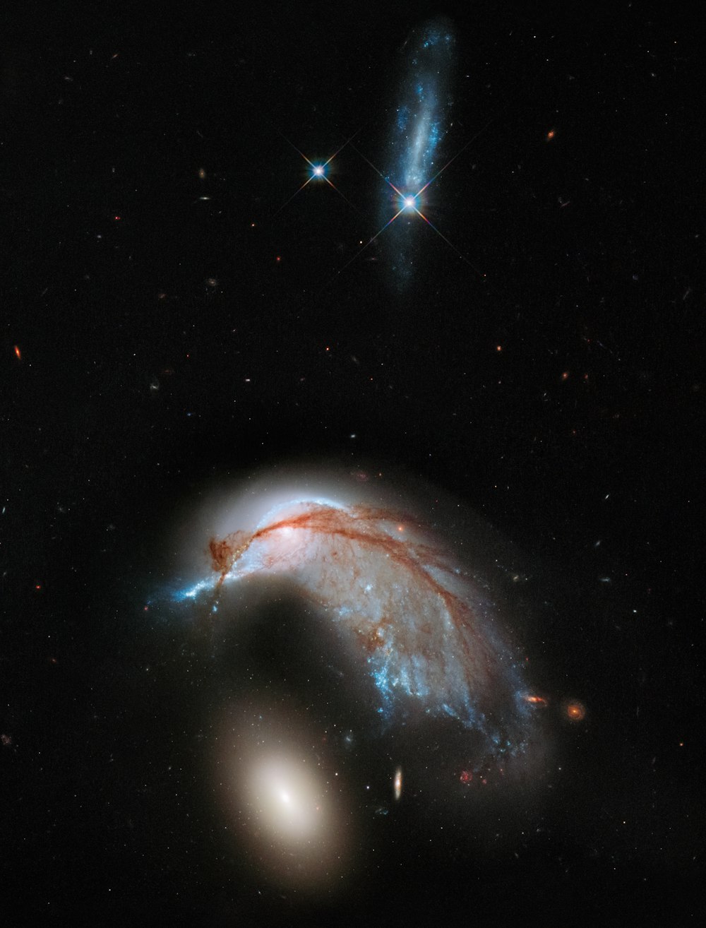 two spiral shaped objects in the dark sky