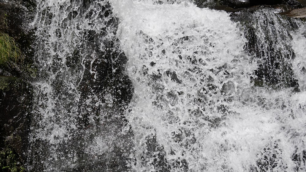 a man standing in front of a waterfall