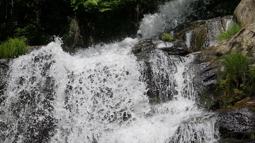 a man riding a surfboard on top of a waterfall