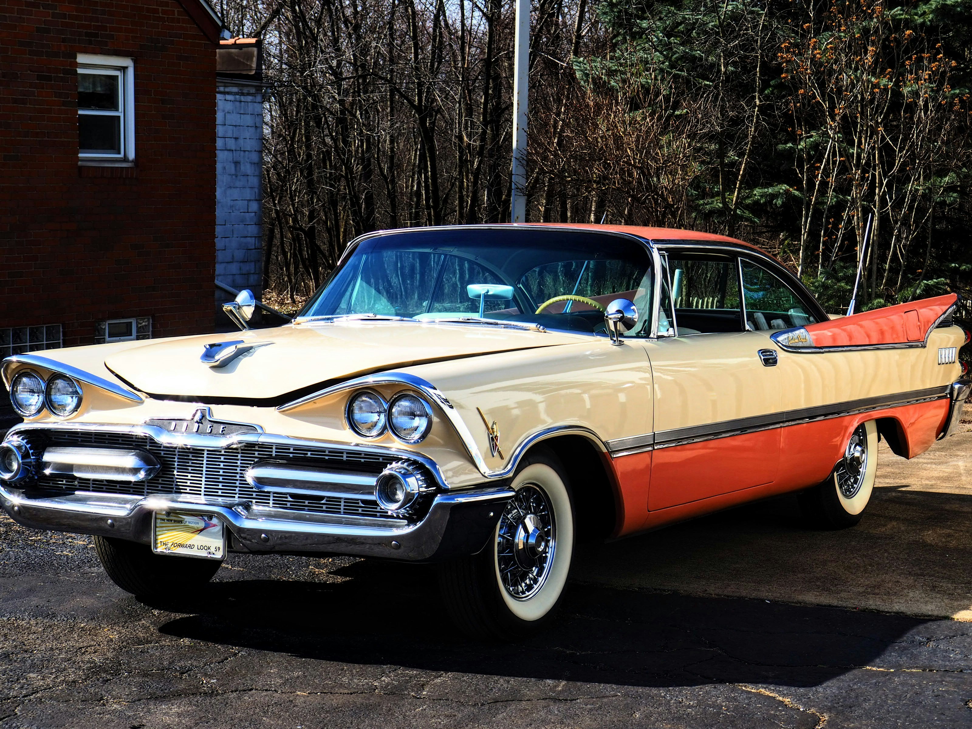 a tan and orange car parked in a parking lot