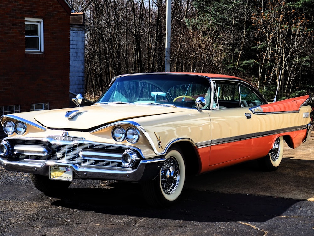 a tan and orange car parked in a parking lot