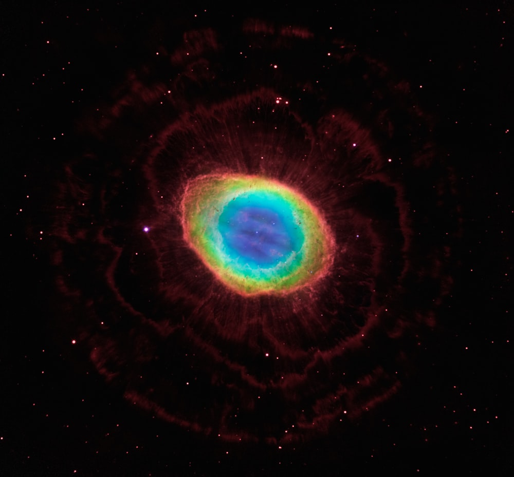 a blue and green ring in the middle of a black sky