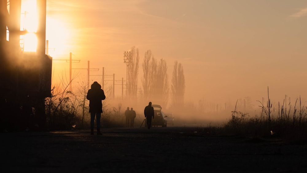 a group of people walking down a dirt road