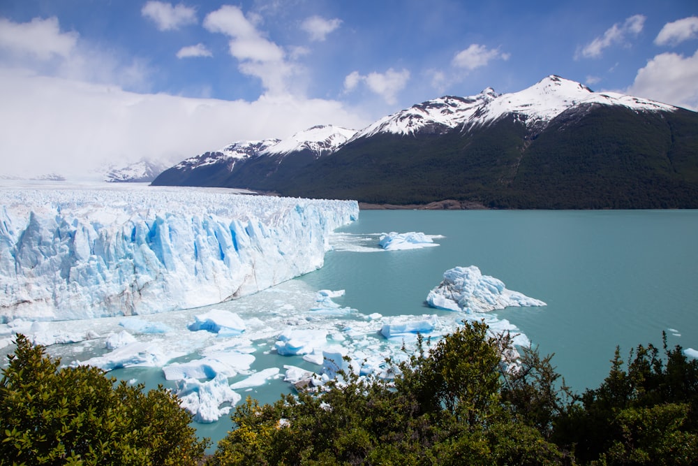 a large glacier with mountains in the background