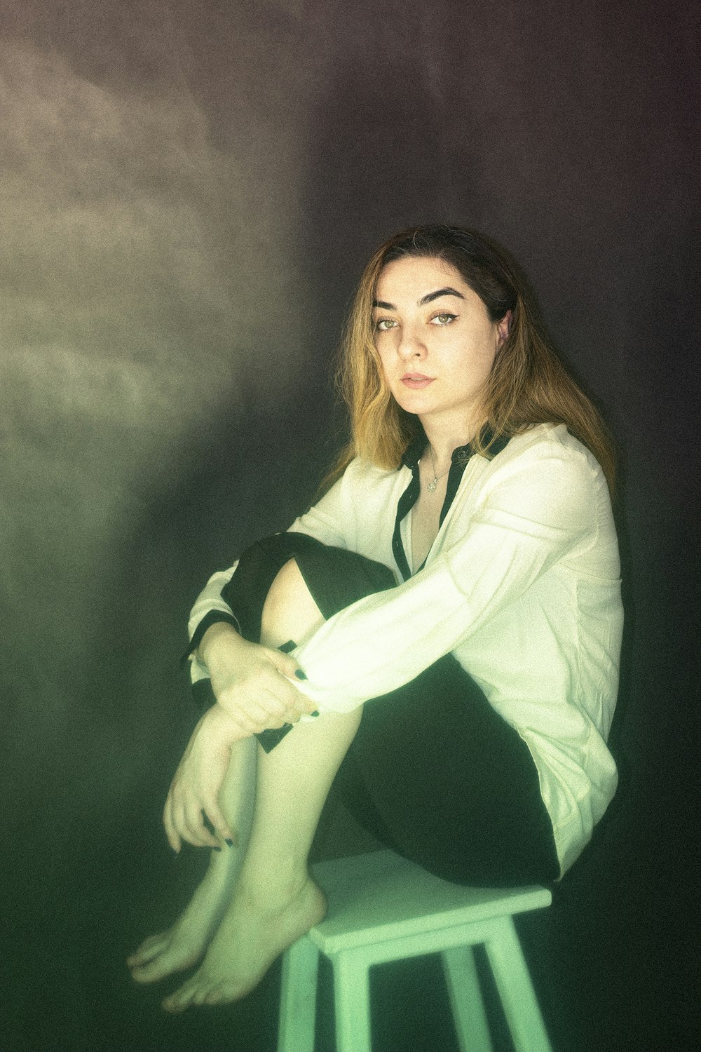 a woman sitting on top of a stool