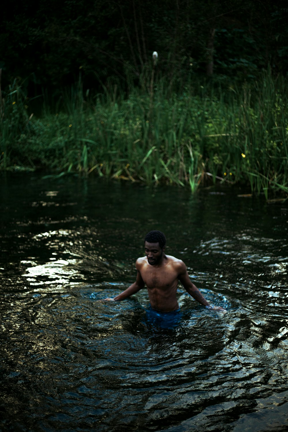 a man wading in a river with a frisbee