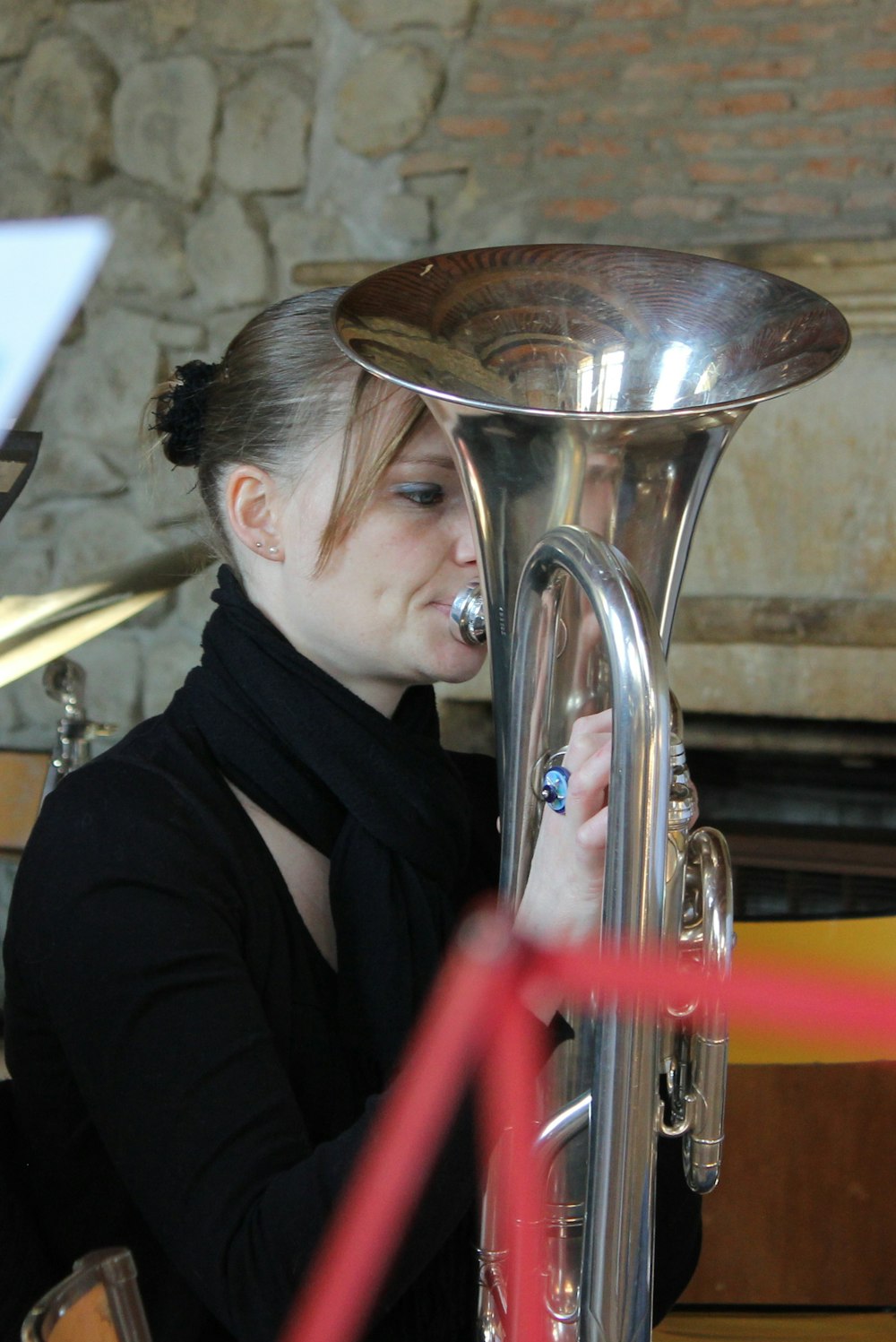 a woman playing a silver instrument in a room