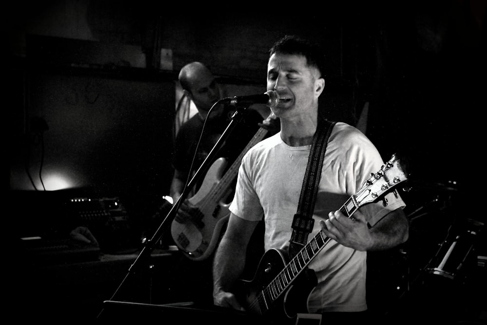 a man singing into a microphone while holding a guitar