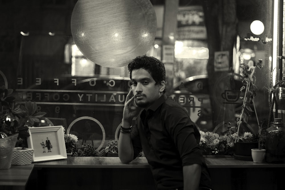 a man sitting at a table in front of a window