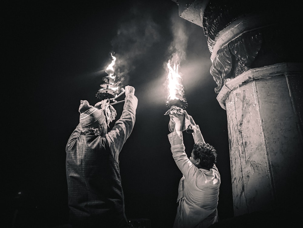 a couple of people holding torches in their hands