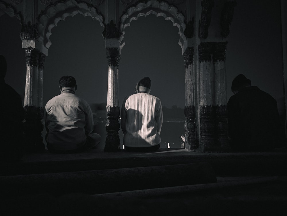 a couple of men sitting next to each other