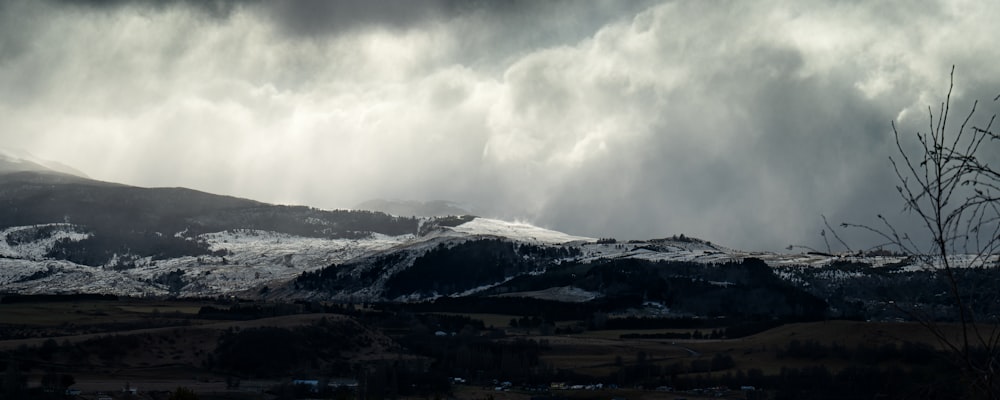 a mountain covered in snow under a cloudy sky